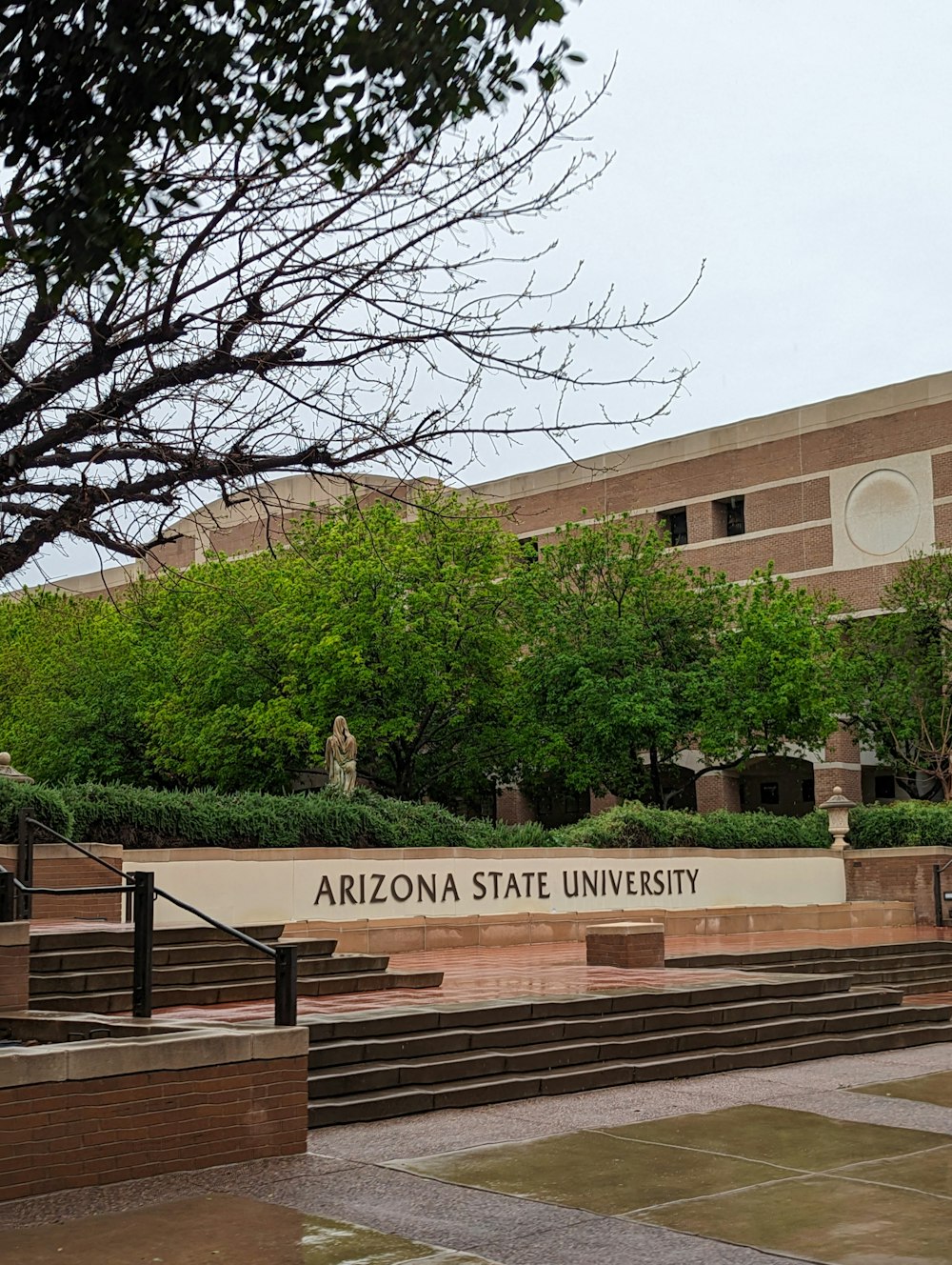 o sinal da universidade estadual arizona está em frente a um prédio