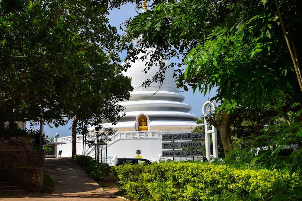 a large white building surrounded by trees and bushes