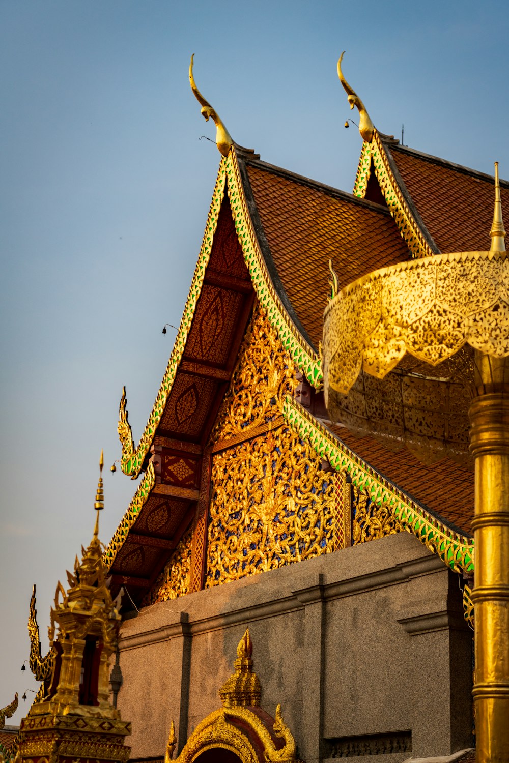 a building that has a gold roof and a light pole in front of it