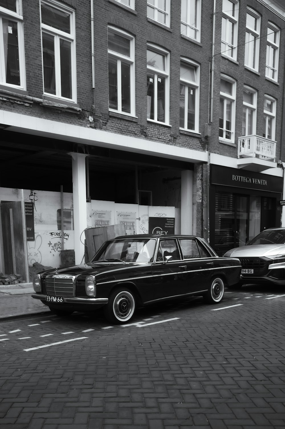 a black and white photo of a car parked on the side of the road