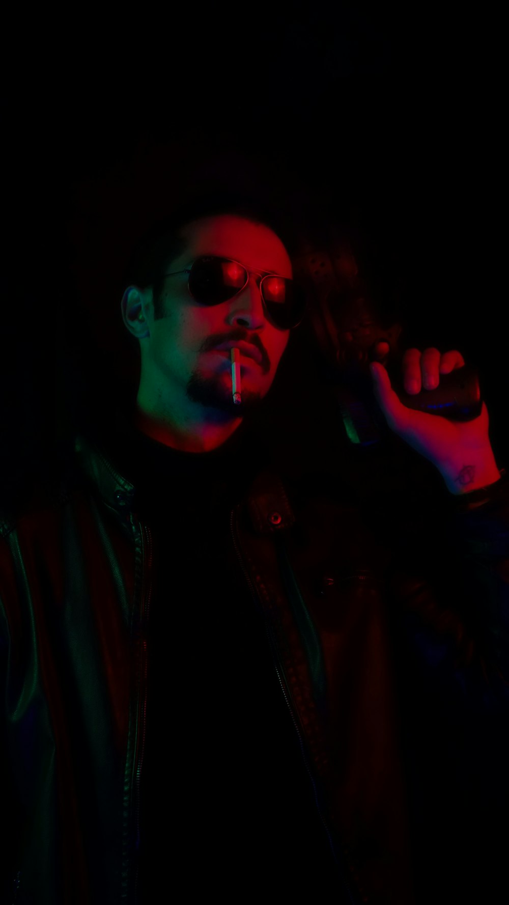 Un hombre fumando un cigarrillo en la oscuridad