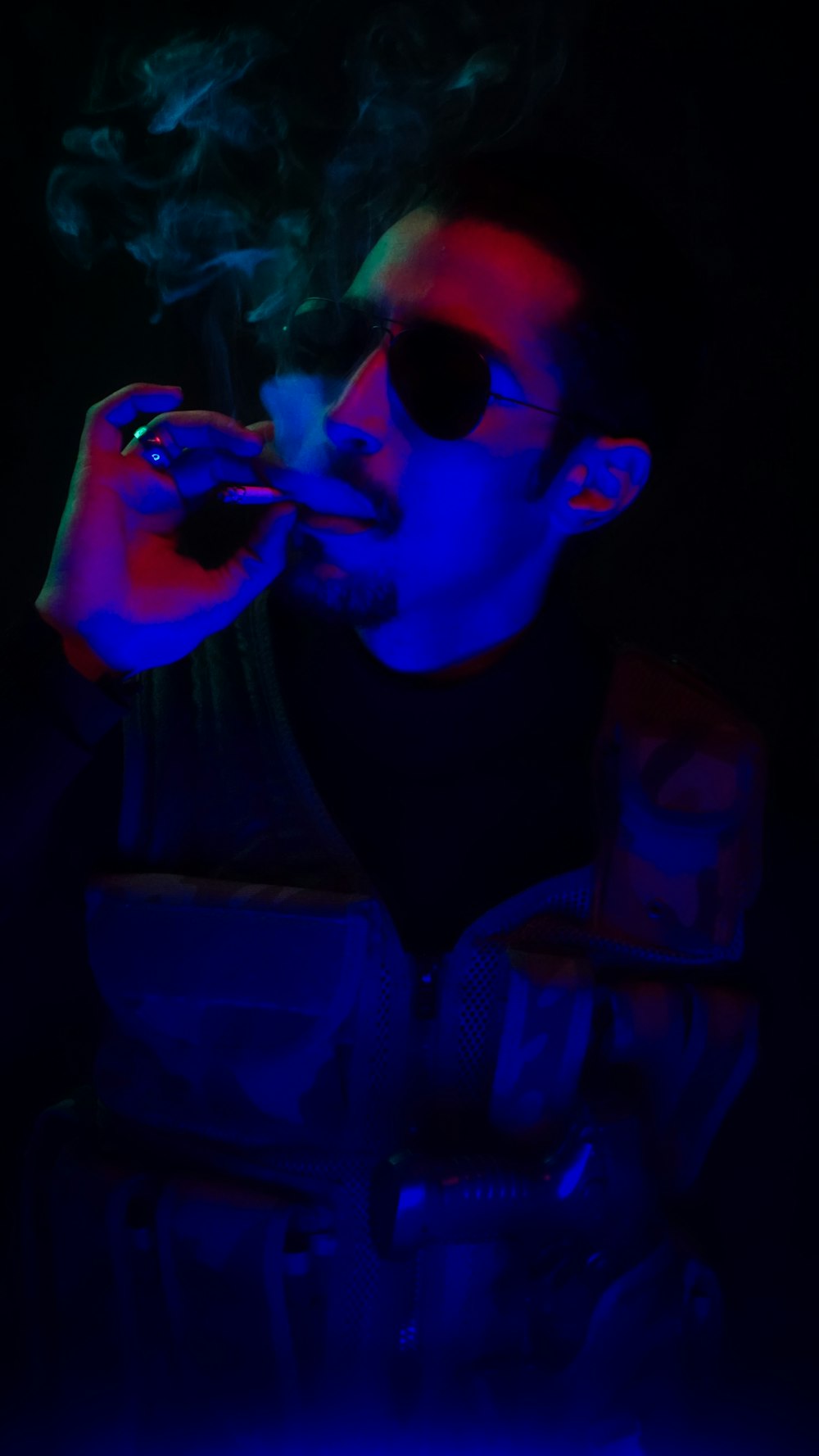 a man smoking a cigarette in the dark