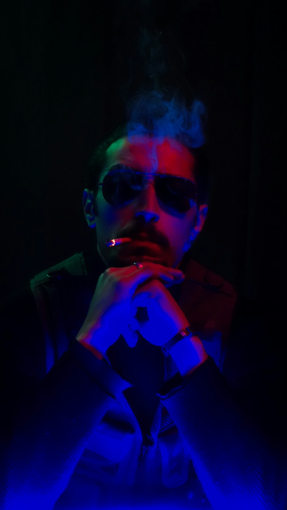 a man wearing sunglasses and smoking a cigarette