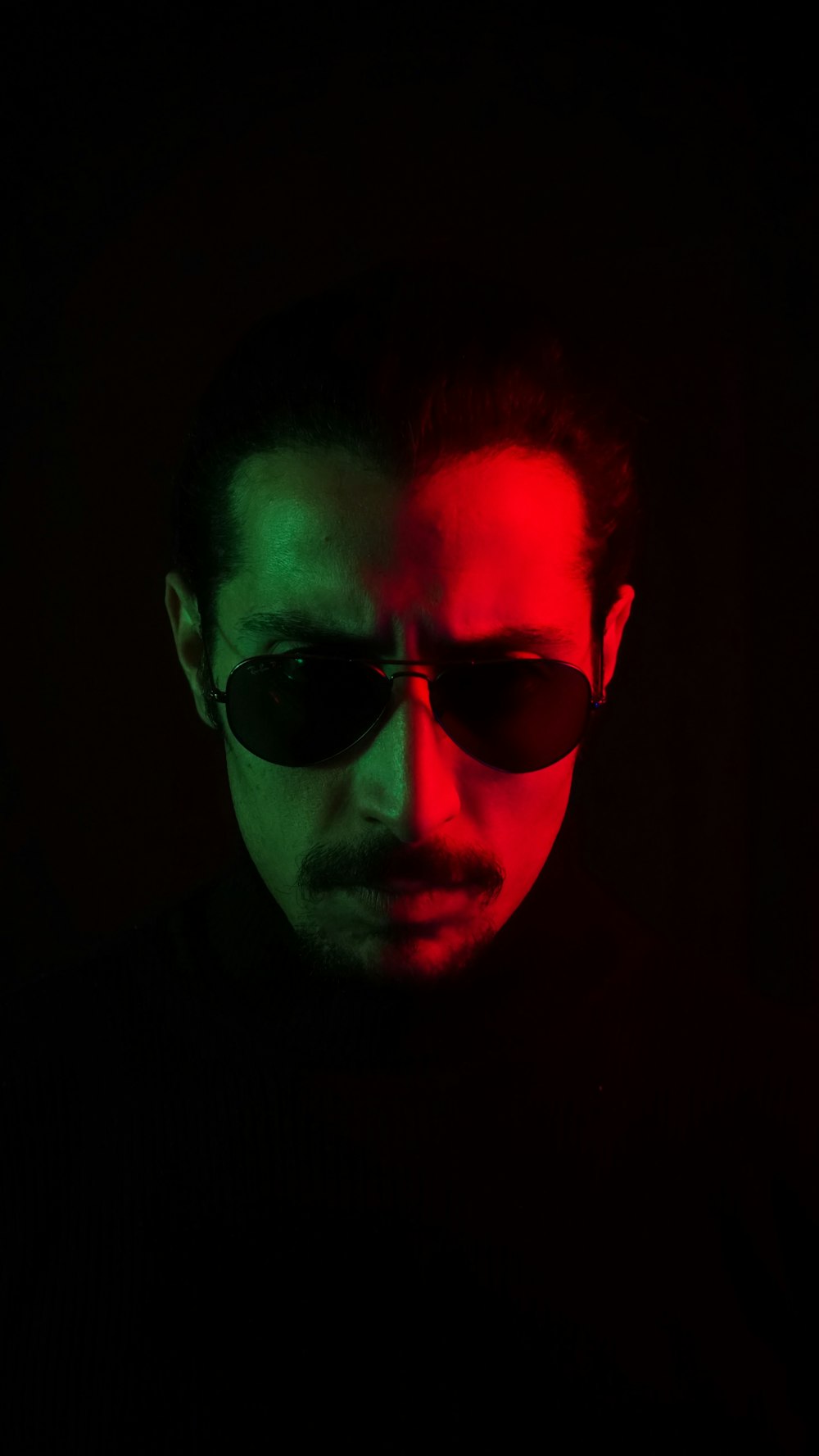 a man wearing sunglasses in a dark room