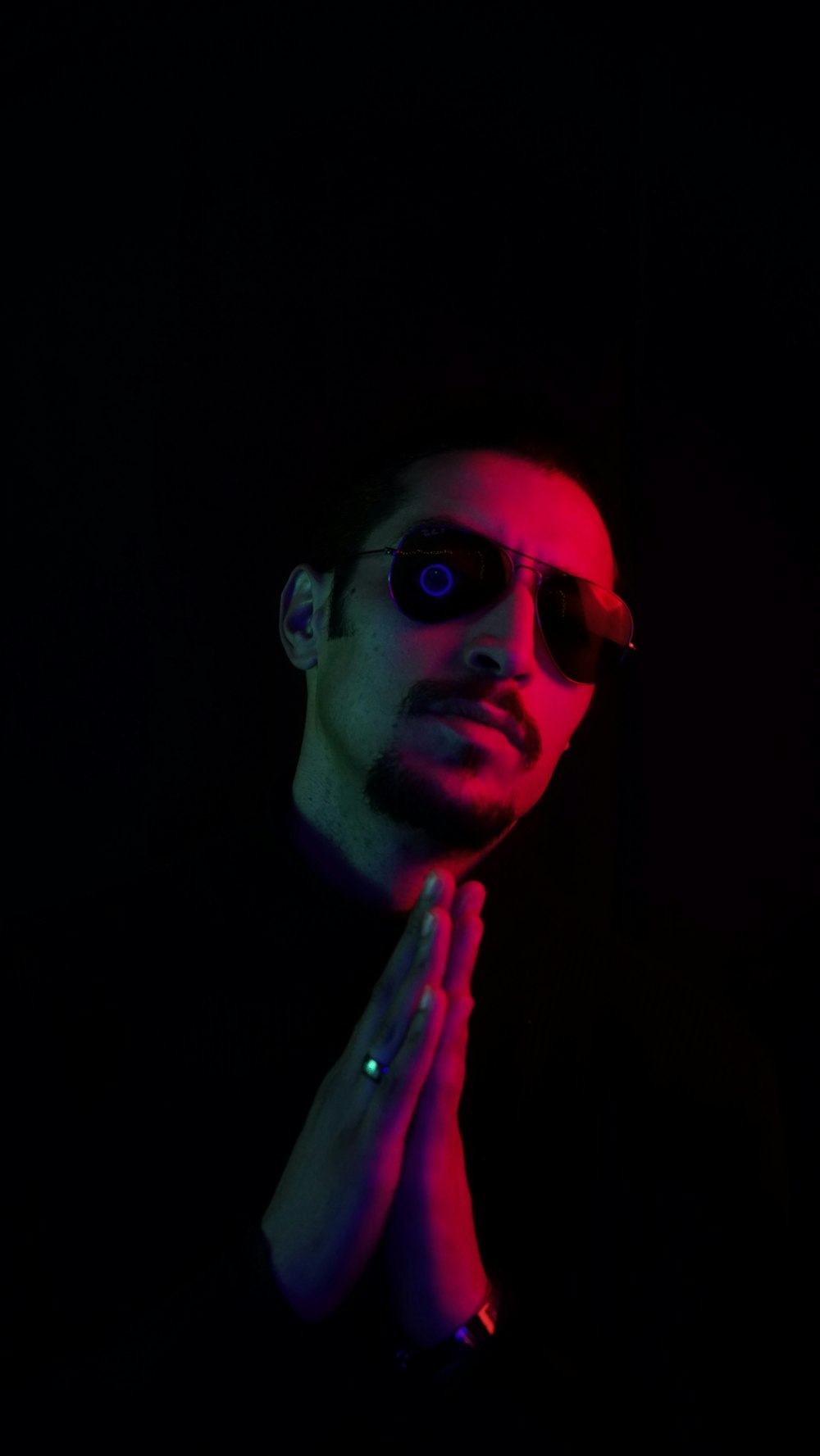 a man in a dark room with a pair of sunglasses on his face