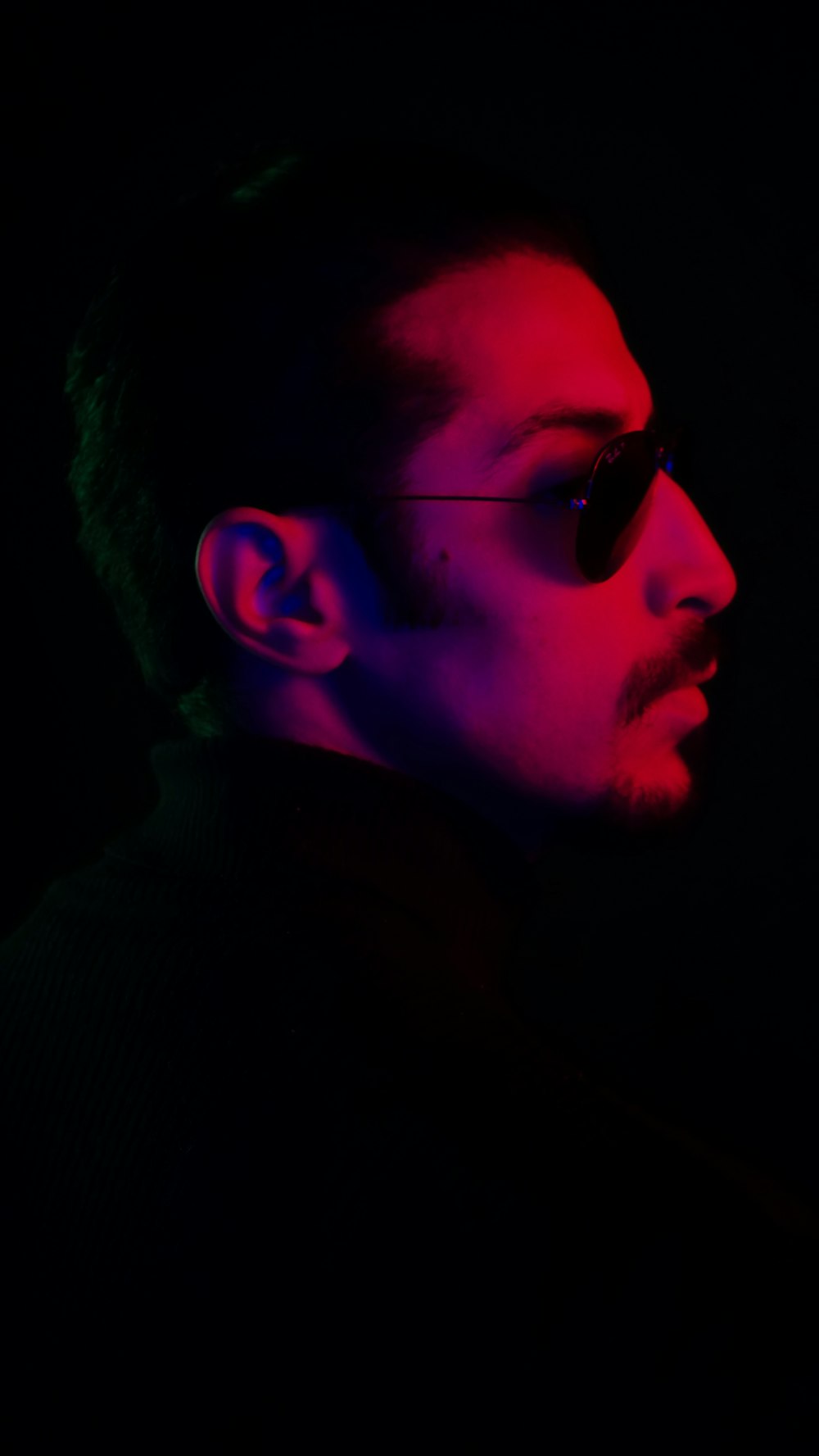 a man wearing sunglasses in the dark
