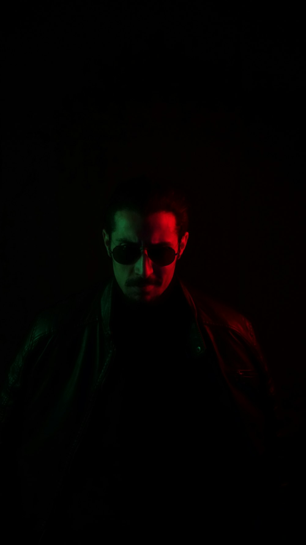 a man in a dark room wearing sunglasses
