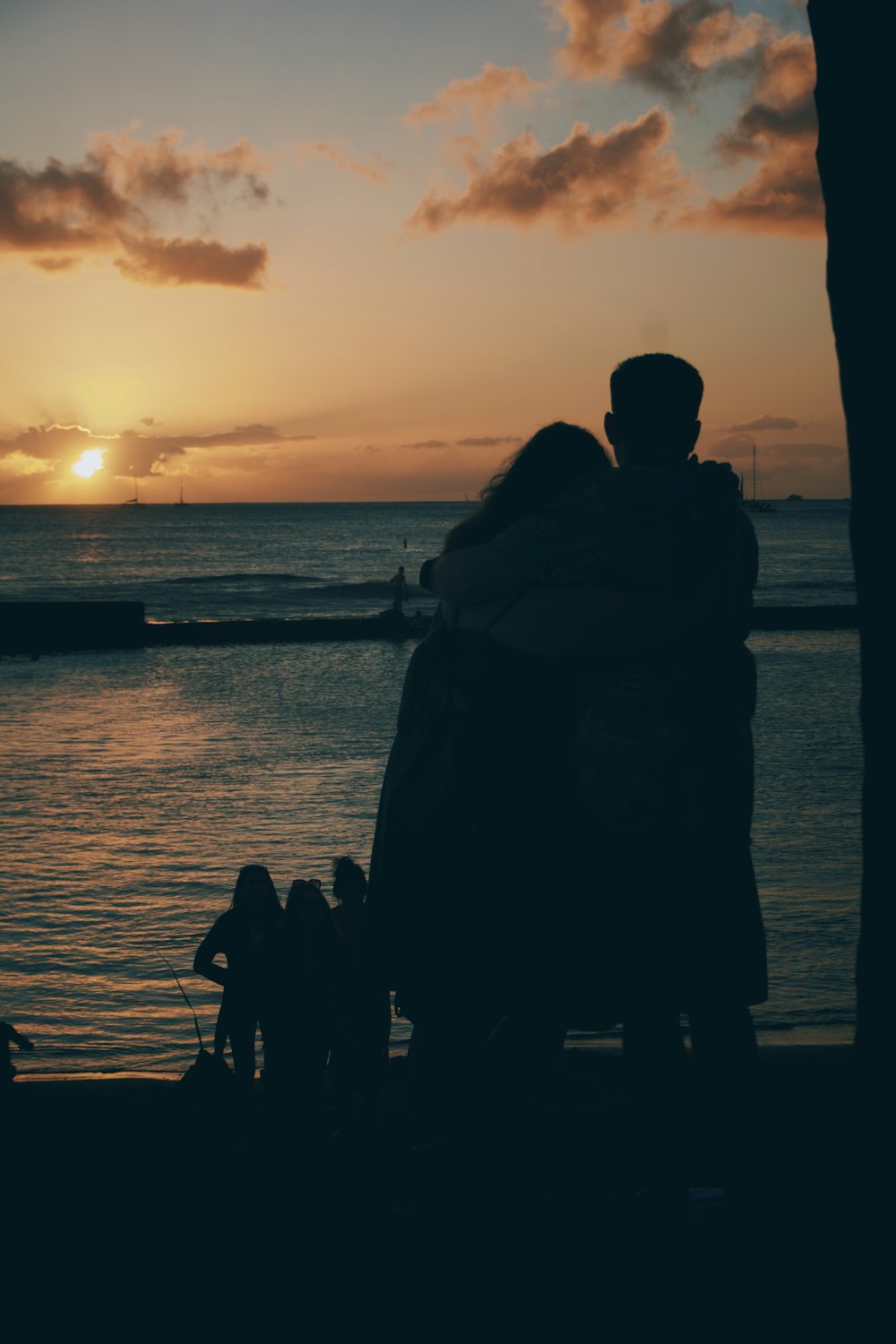 a couple of people standing next to a body of water