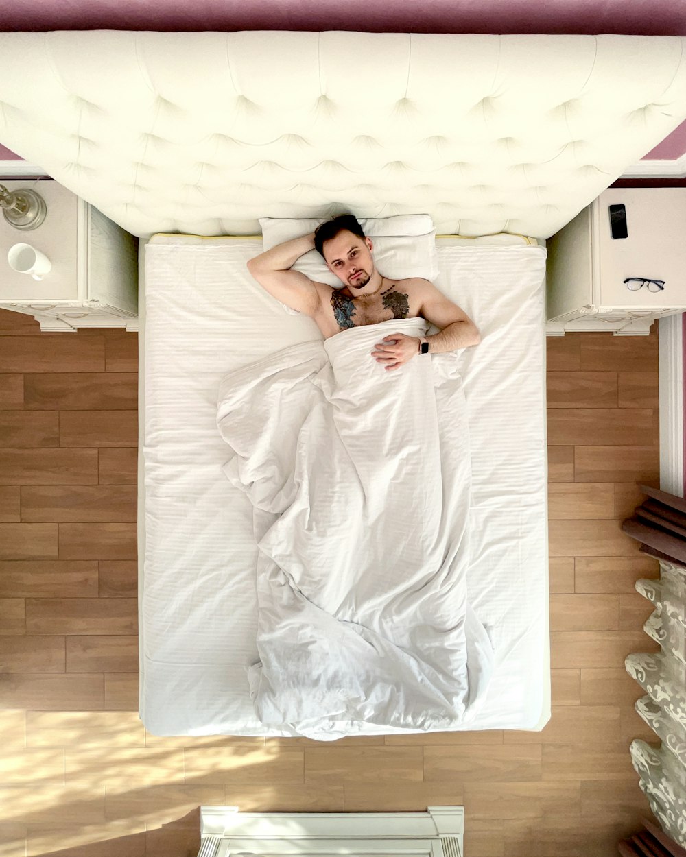 a man laying in a bed under a white blanket