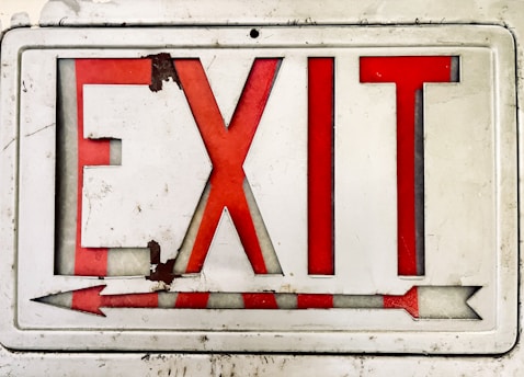 a close up of a red and white sign with an arrow