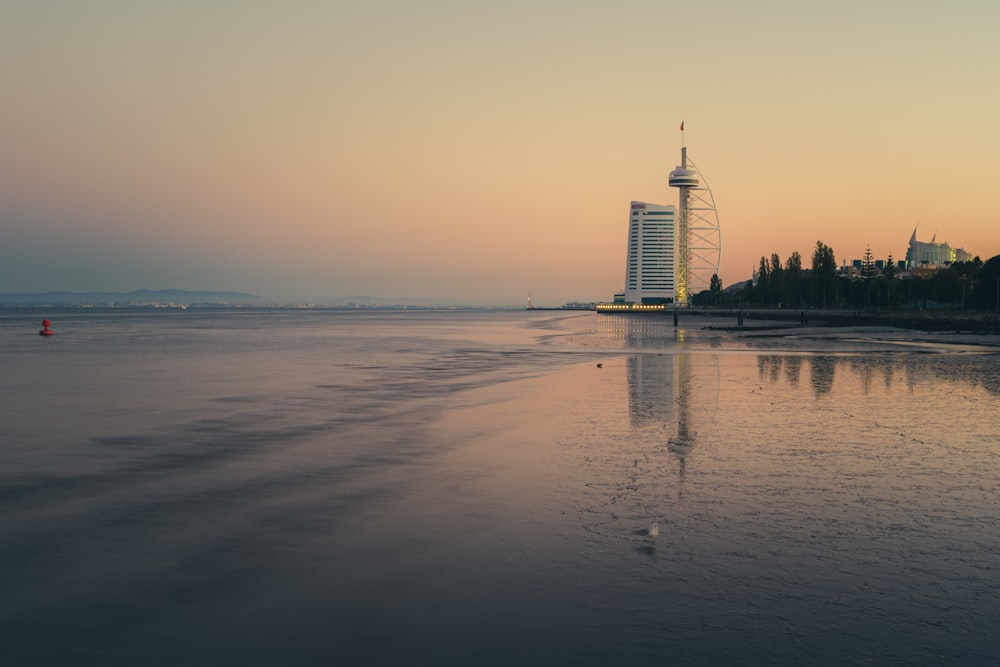 a large body of water with a tall building in the background