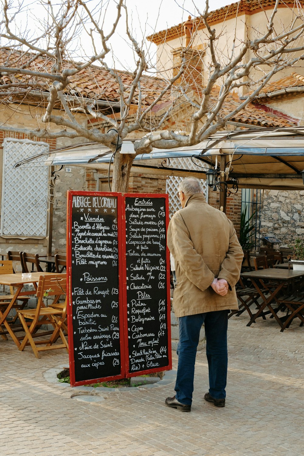 a man standing in front of a menu board