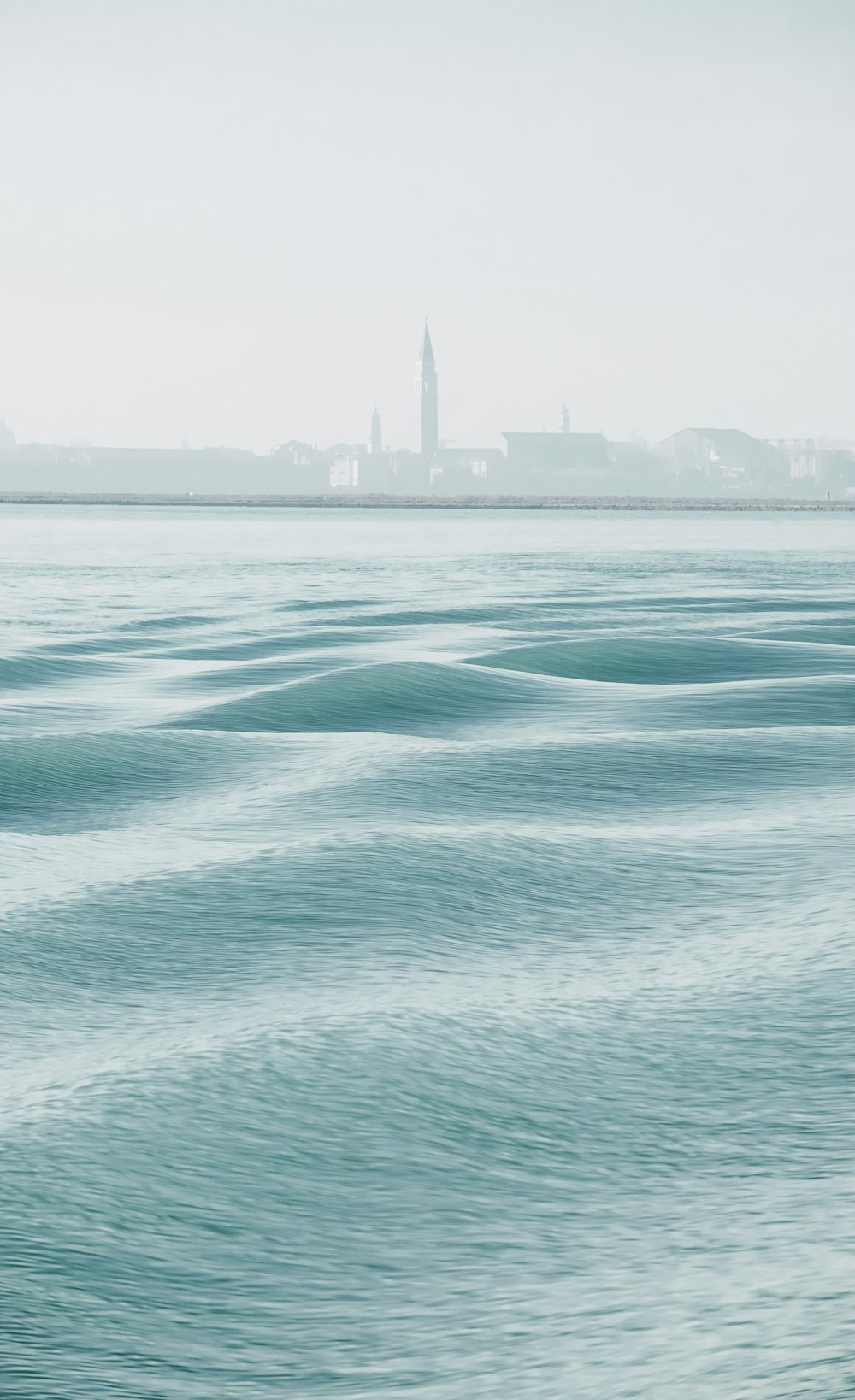 a large body of water with a city in the background