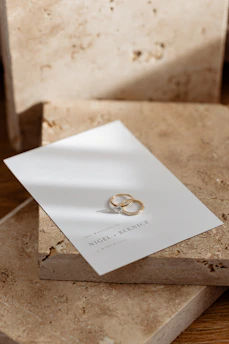 An elegant ivory and gold wedding invitation set on a textured ivory background.