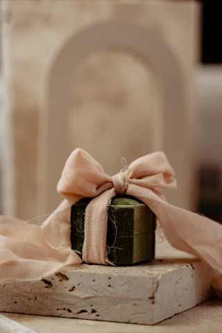 a small present box with a pink ribbon tied around it