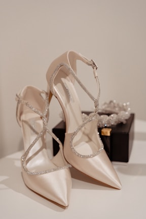 An elegant pair of glossy designer heels placed next to a silk scarf in muted tones.