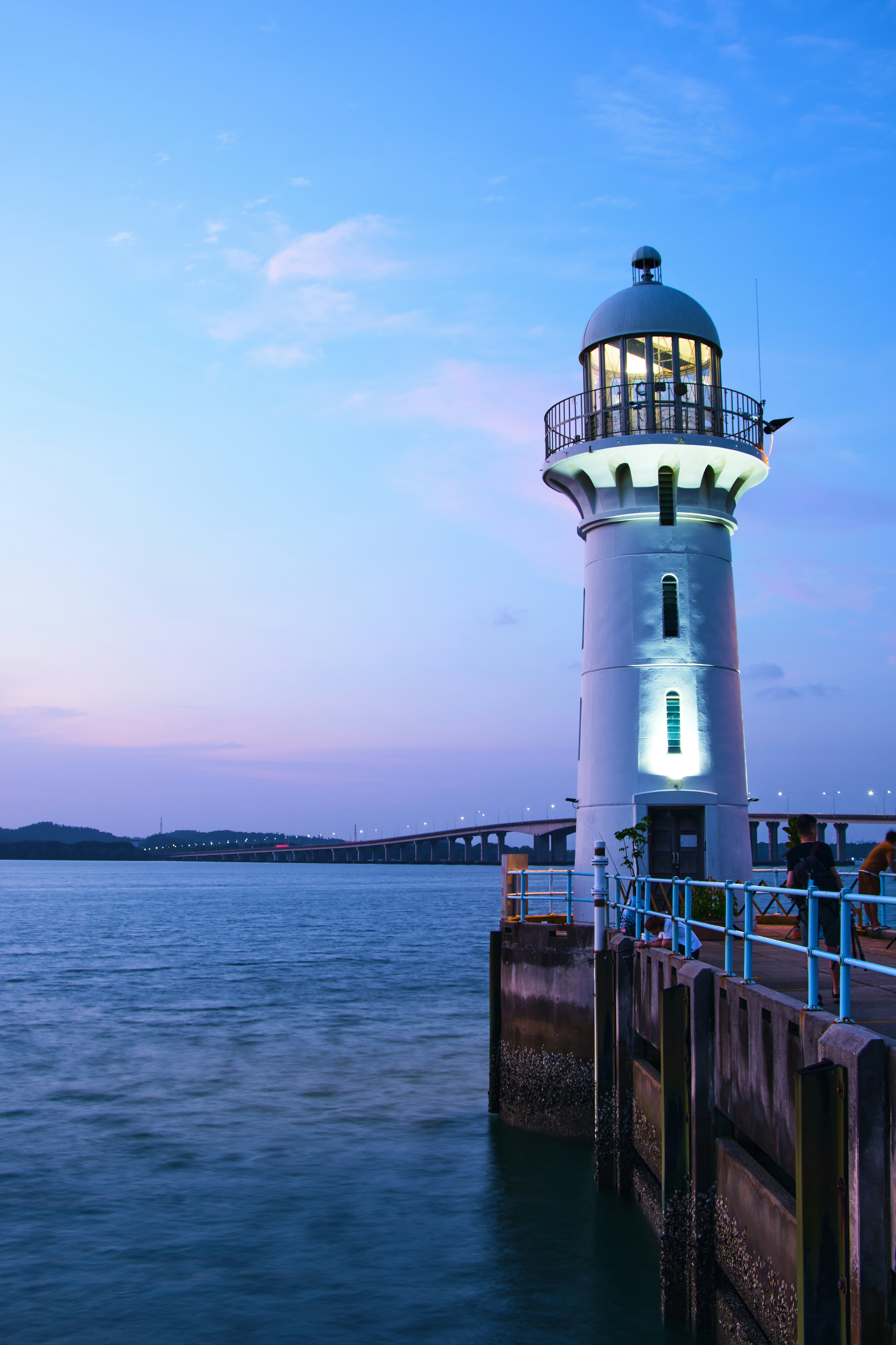a light house sitting on top of a pier next to the ocean