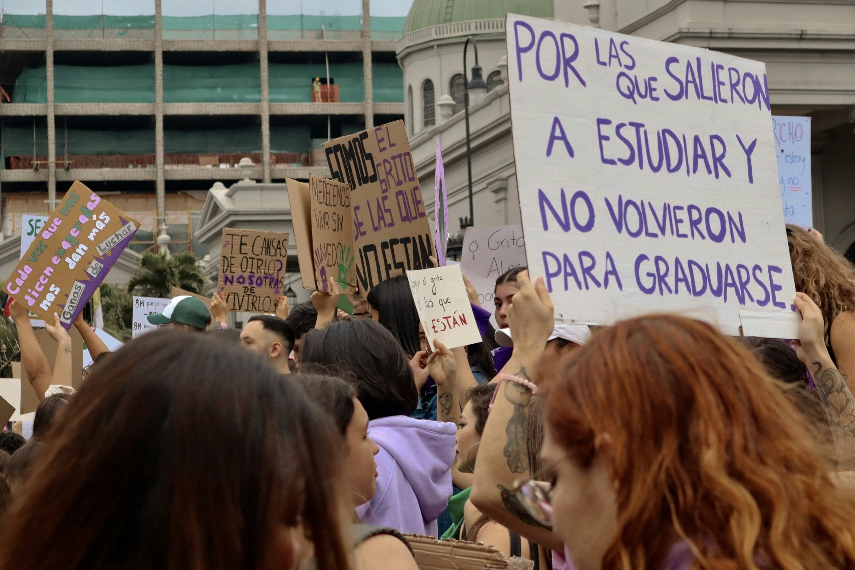 a large group of people holding signs in the air
