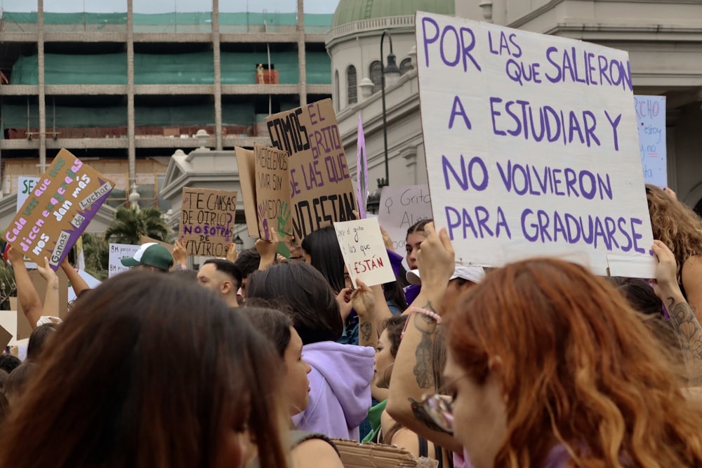 a large group of people holding signs in the air