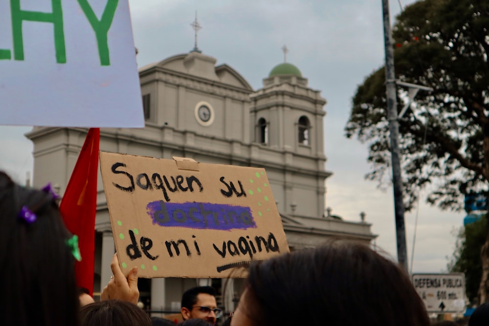 a group of people holding signs in front of a building