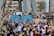 A large group of people, predominantly women, are gathered for a protest or rally. They are holding signs with various messages, many of which focus on women's rights and empowerment. Some participants are wearing purple, a color often associated with feminist movements. The atmosphere is lively and engaged, with a sense of solidarity among the crowd.