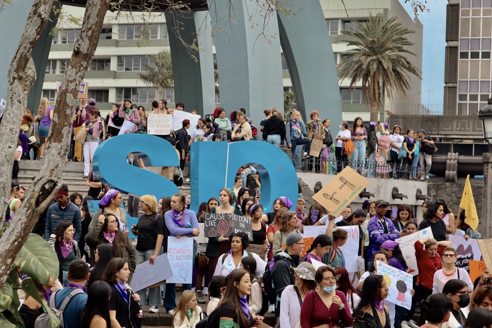 a large group of people holding signs in front of a building