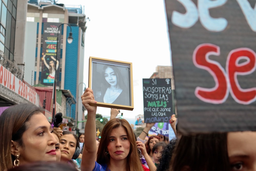 a crowd of people holding up signs and pictures