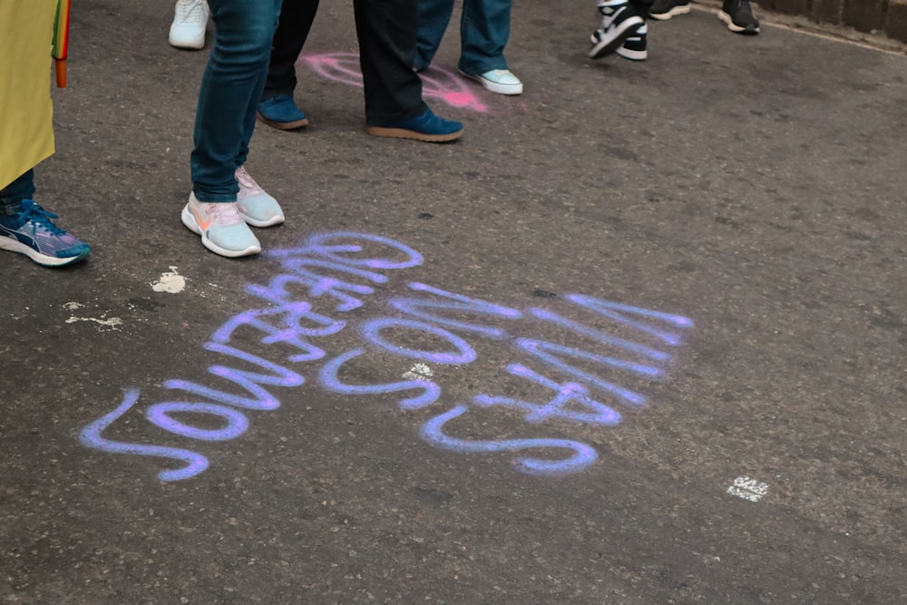 a group of people standing next to each other on a sidewalk