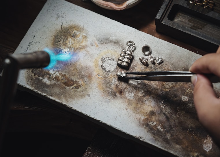 a person using a pair of scissors to cut out a piece of metal