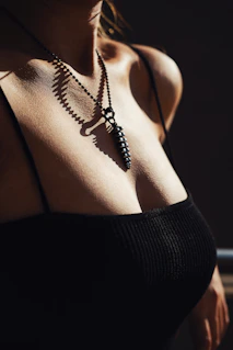 a woman wearing a black top and a necklace