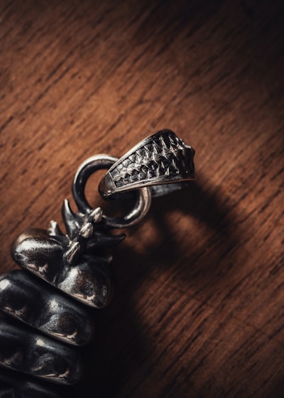 A close-up of intricate silver jewelry pieces on a wooden table.