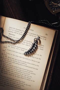 Open ancient book with a golden compass resting on pages about personal development.