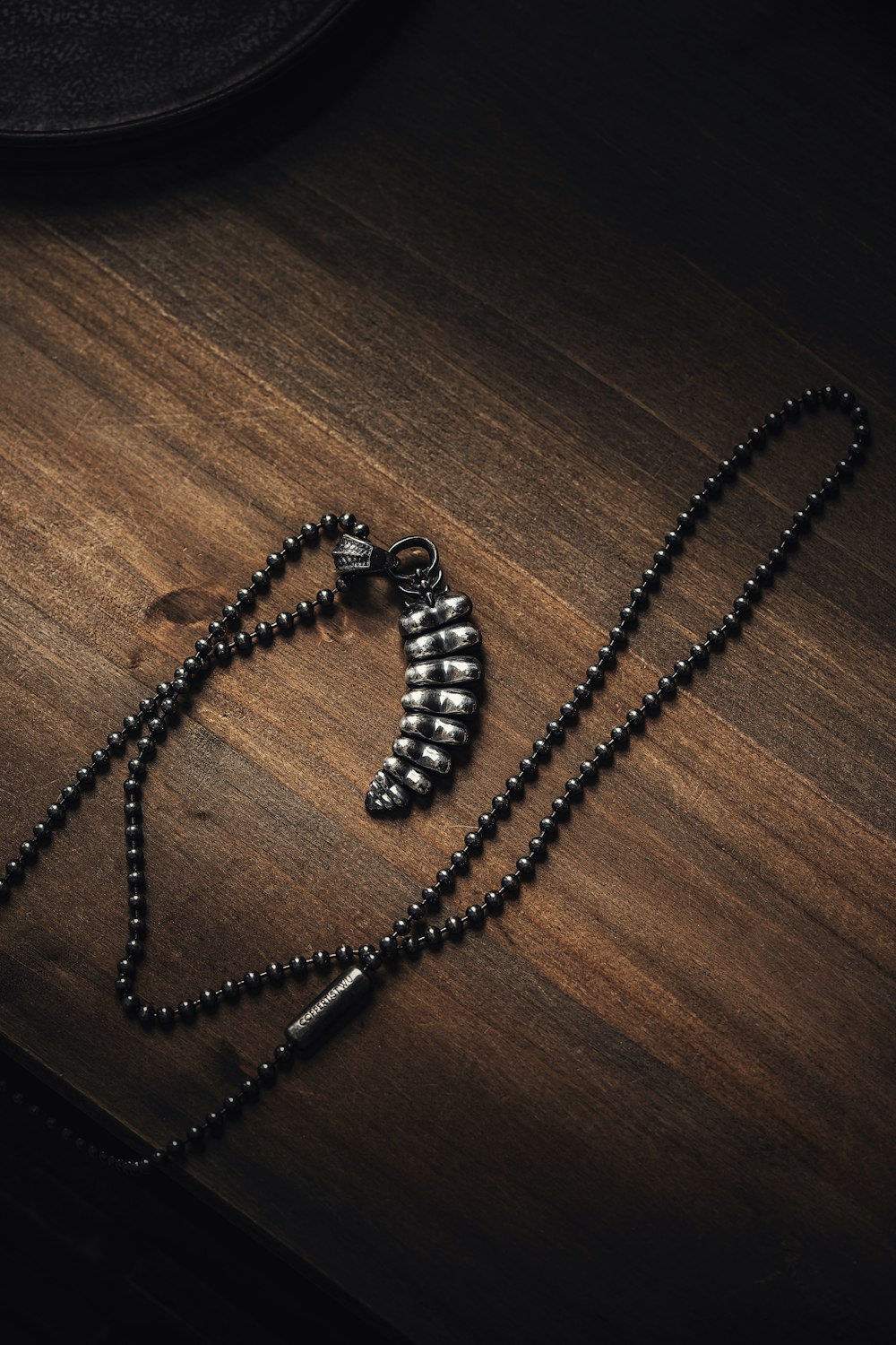 a black beaded necklace on a wooden table
