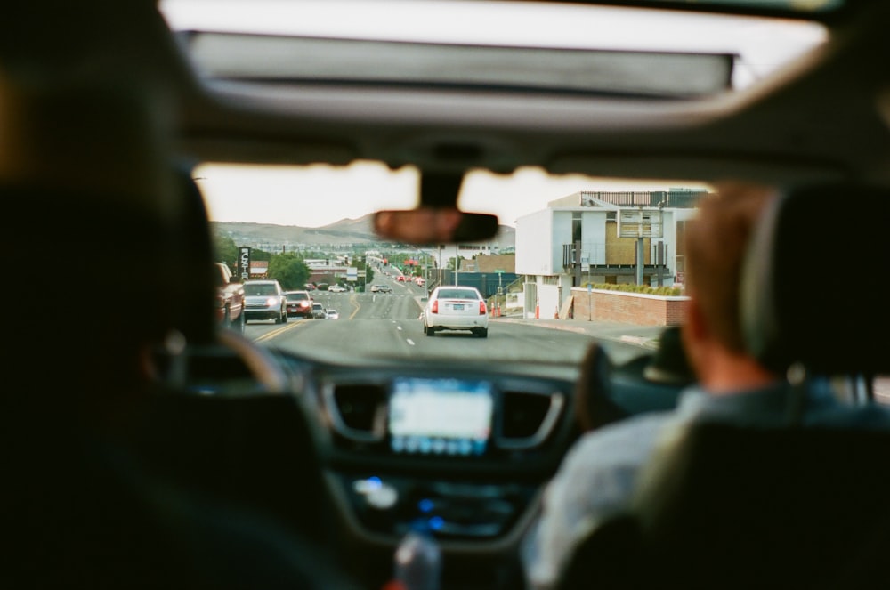 a man driving a car down a street next to a traffic light