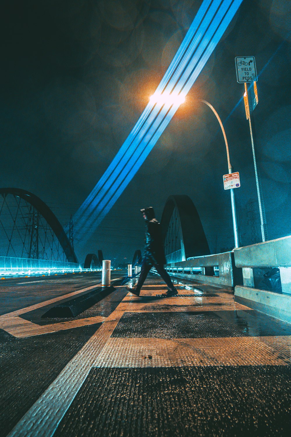 a man walking across a street at night