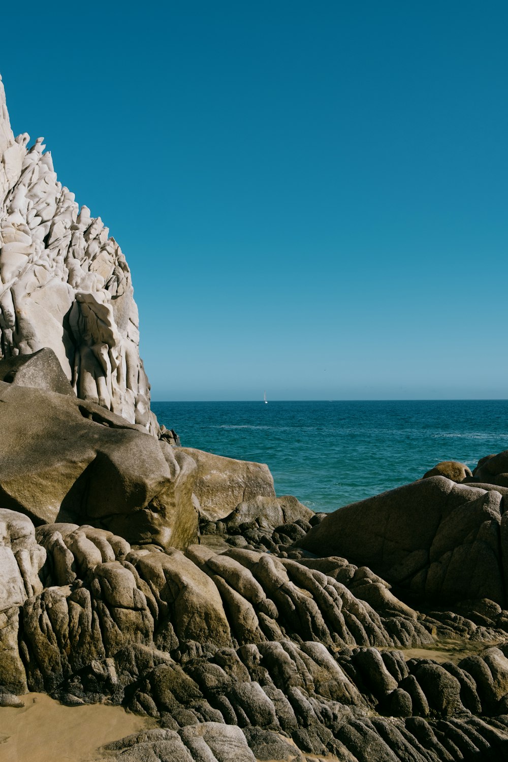 a rock formation on the shore of a beach