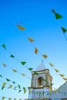 a church steeple with a bell tower and green and yellow flags