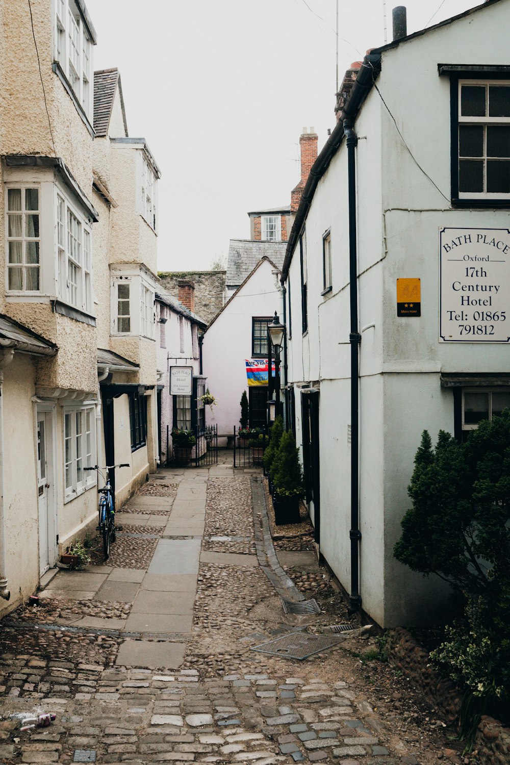 a narrow cobblestone street lined with white buildings