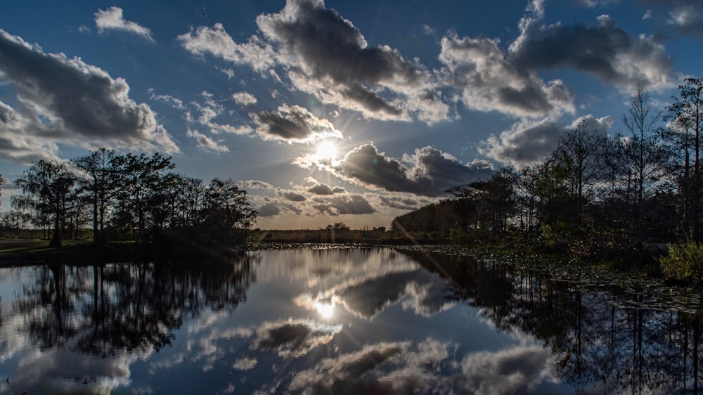 El sol brilla a través de las nubes sobre un lago