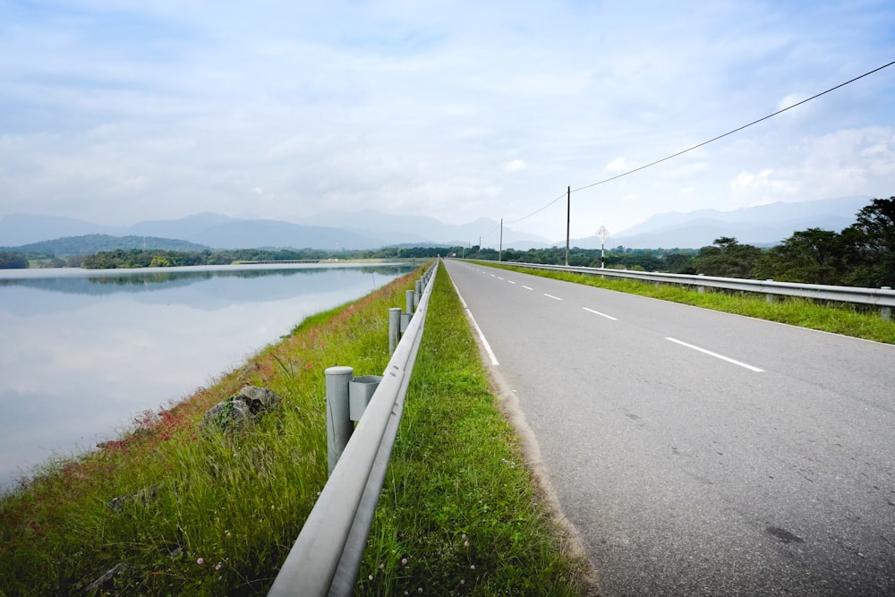 uma estrada ao lado de um grande corpo de água