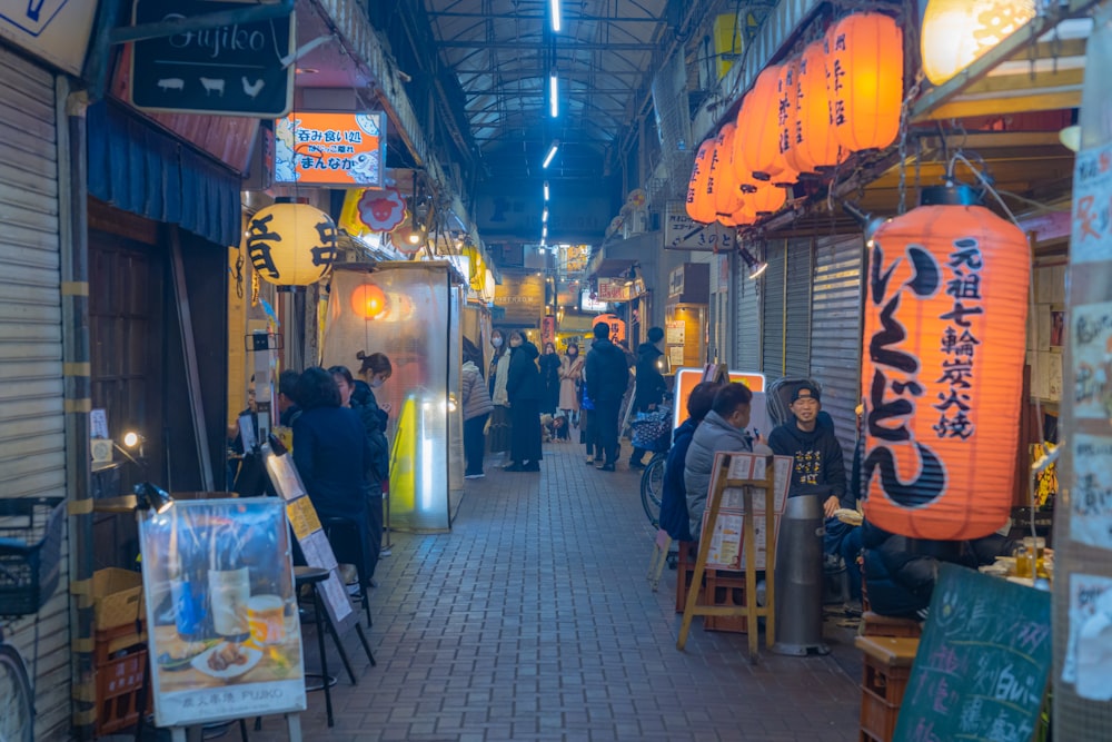 a group of people walking down a street next to shops