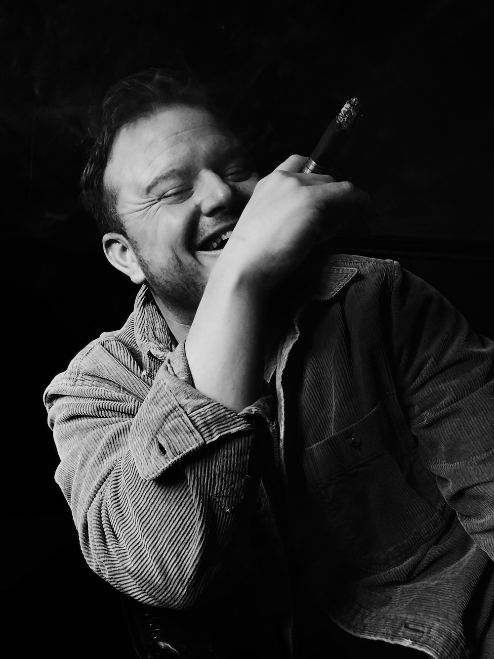 a man smoking a cigarette in a black and white photo