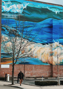 Vibrant mural on a brick wall featuring ocean waves and local wildlife.