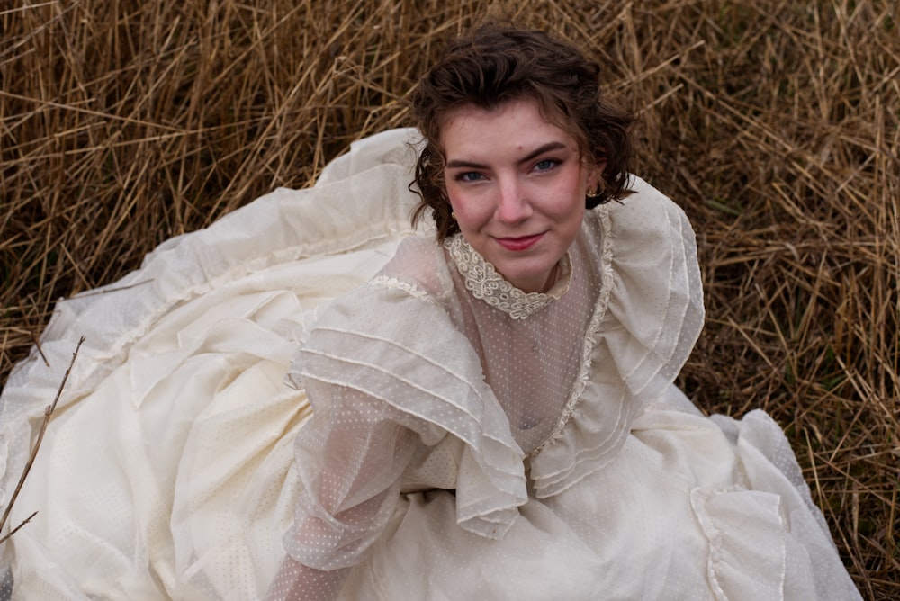 a woman in a white dress laying on the ground