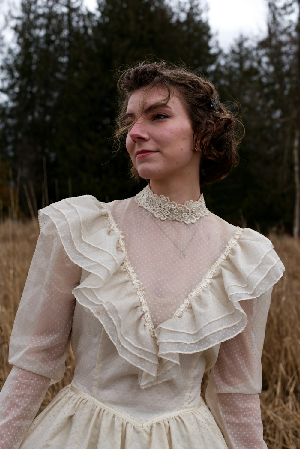 a woman in a white dress standing in a field