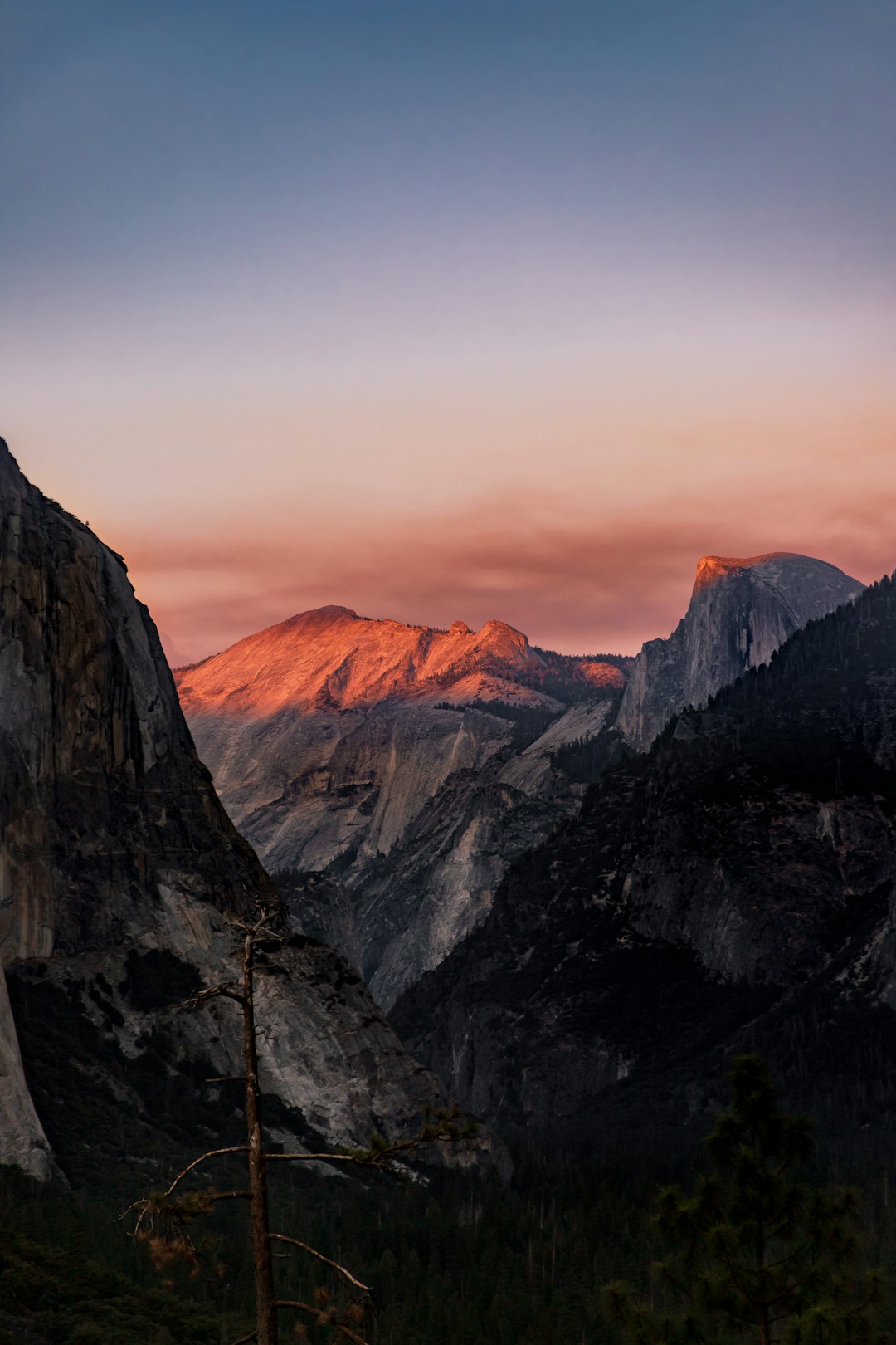 the sun is setting on a mountain range