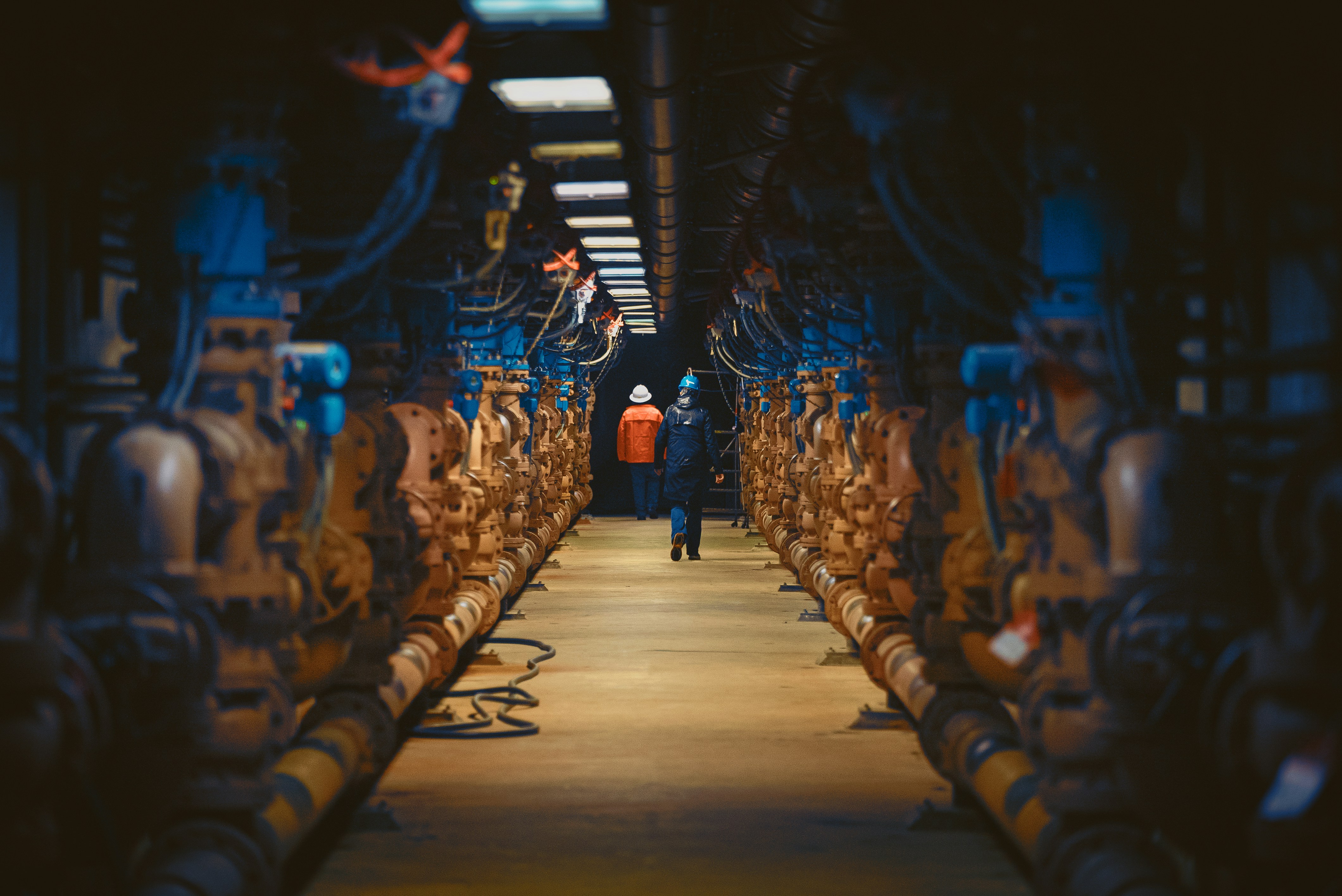 a man standing in a large room with lots of pipes