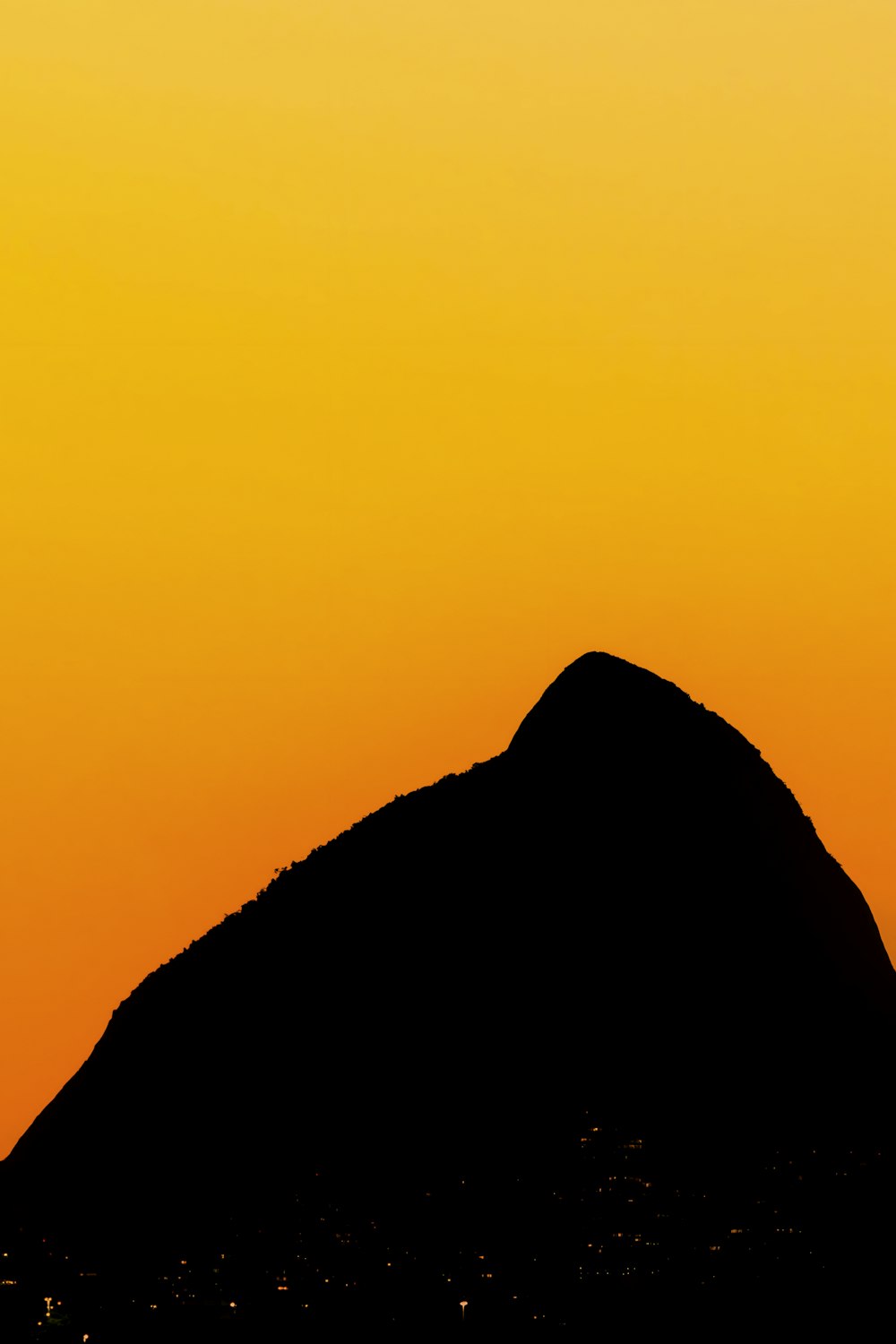 a plane flying over a mountain at sunset