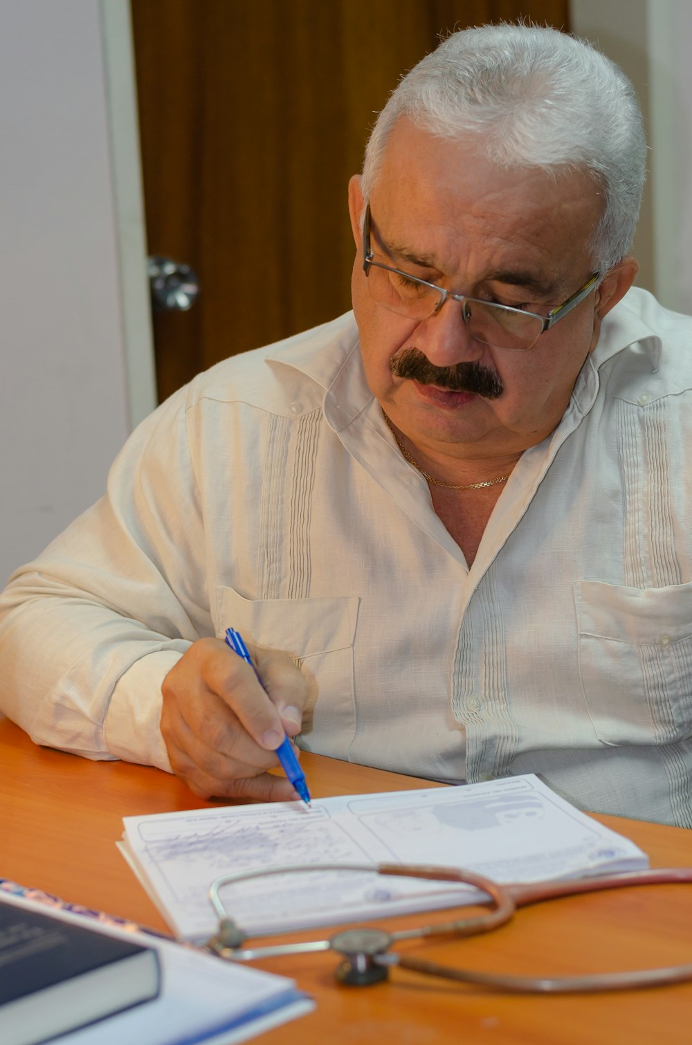 a man sitting at a table writing on a piece of paper