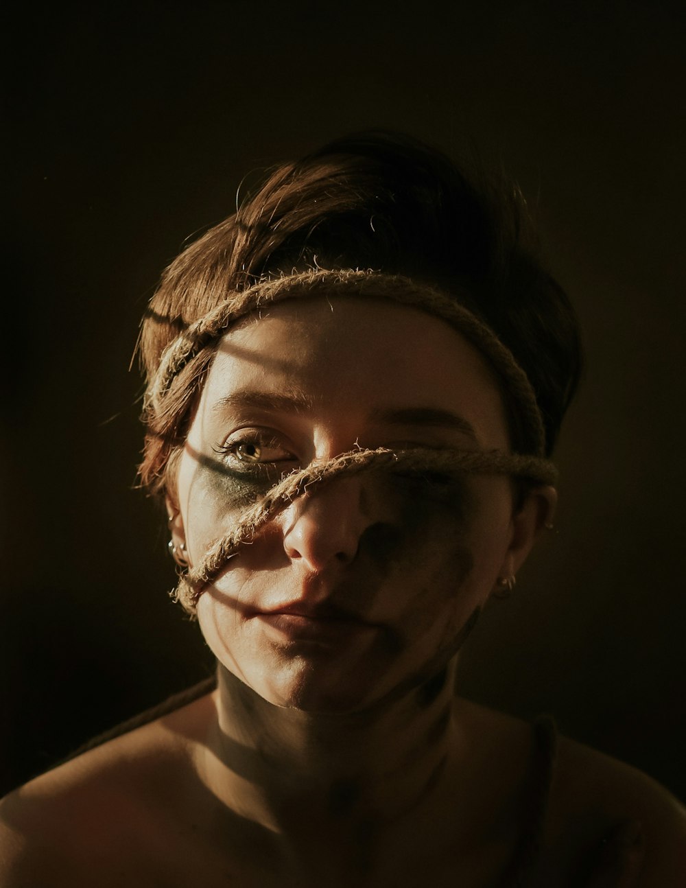 a woman with a rope tied around her face